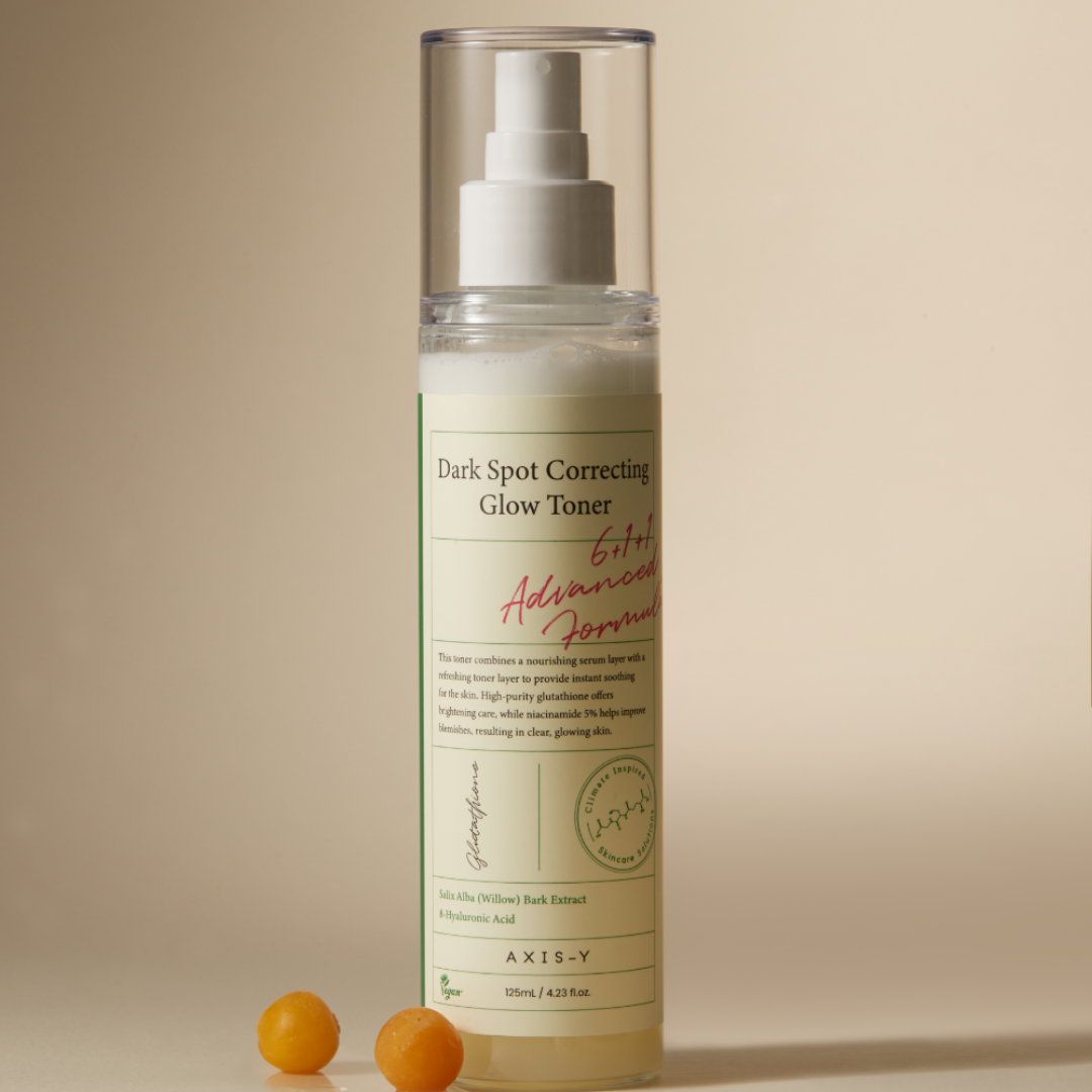 Dark spot correcting glow toner bottle with pump on a beige background