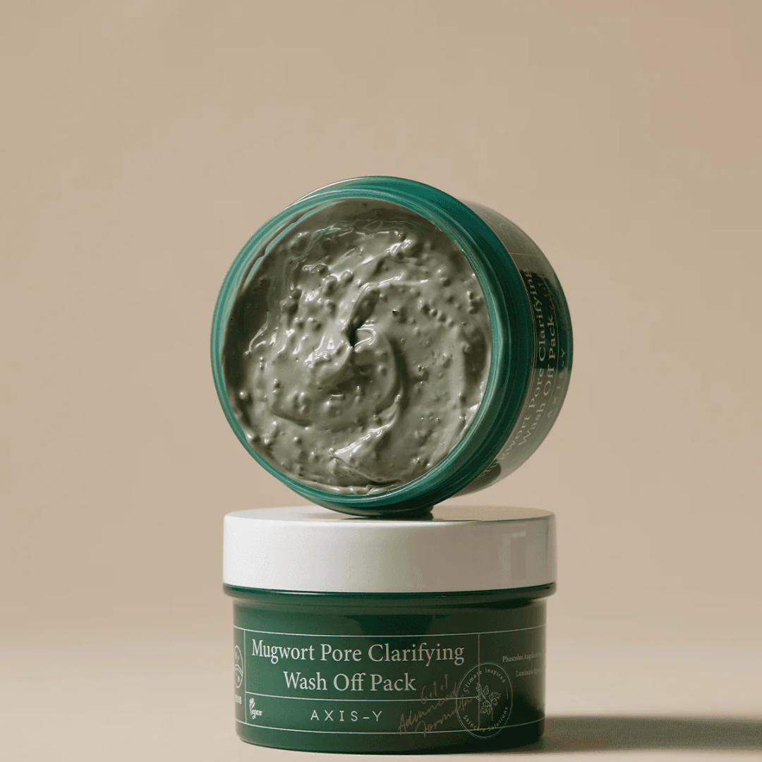 Green jar of Mugwort Pore Clarifying Clay Mask with open lid on beige background