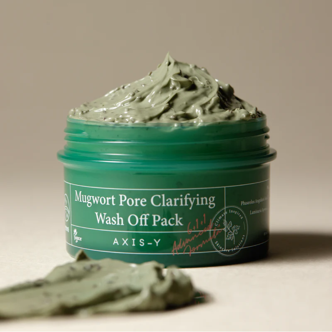 Green jar of Mugwort Pore Clarifying Wash Off Pack by AXIS-Y on a beige background