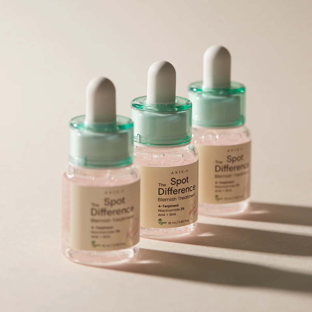 Three skincare dropper bottles labeled 'The Spot Difference' on a neutral background