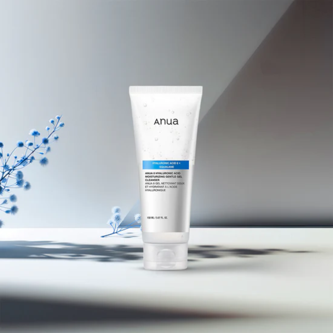 Tube of Anua skincare product on a neutral background with blue flowers.
