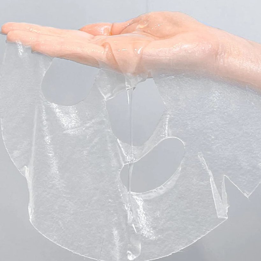 Hand holding a clear mask against a gray background