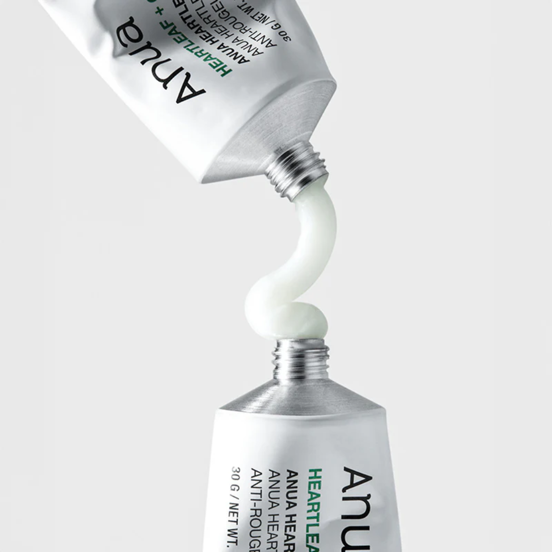 Two ANUA skincare products with white cream being squeezed out on a light gray background