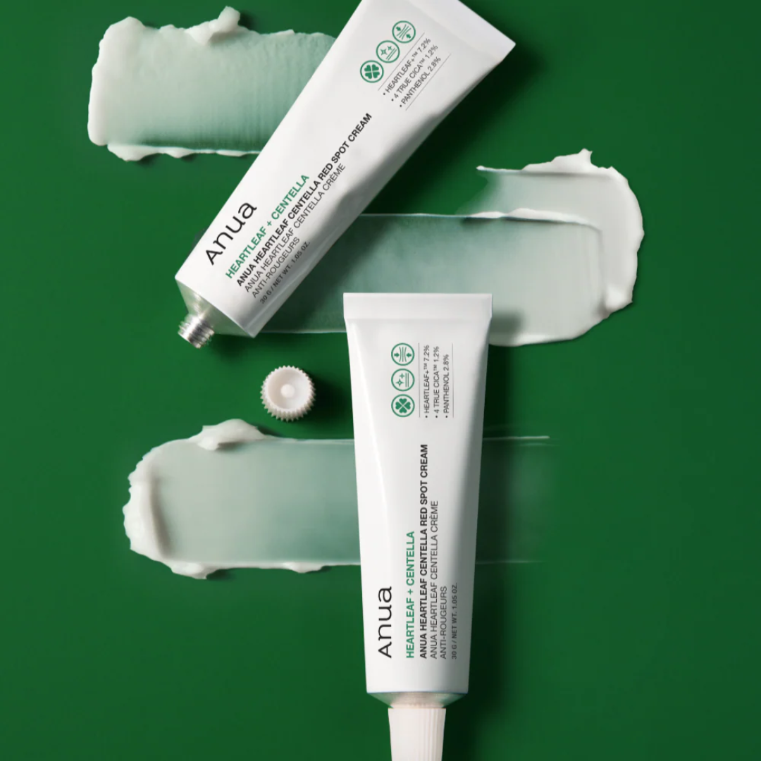 Two tubes of Anua cream on a green background with visible cream smears.
