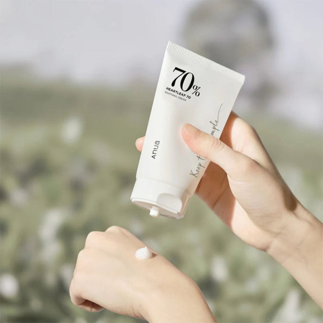 Hand holding a skincare product with a blurred natural background