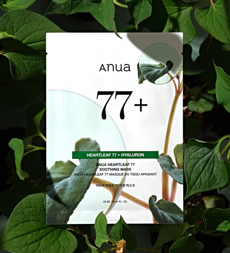 Anua Heartleaf 77+ Hyaluron skincare mask packaging with green leaves background