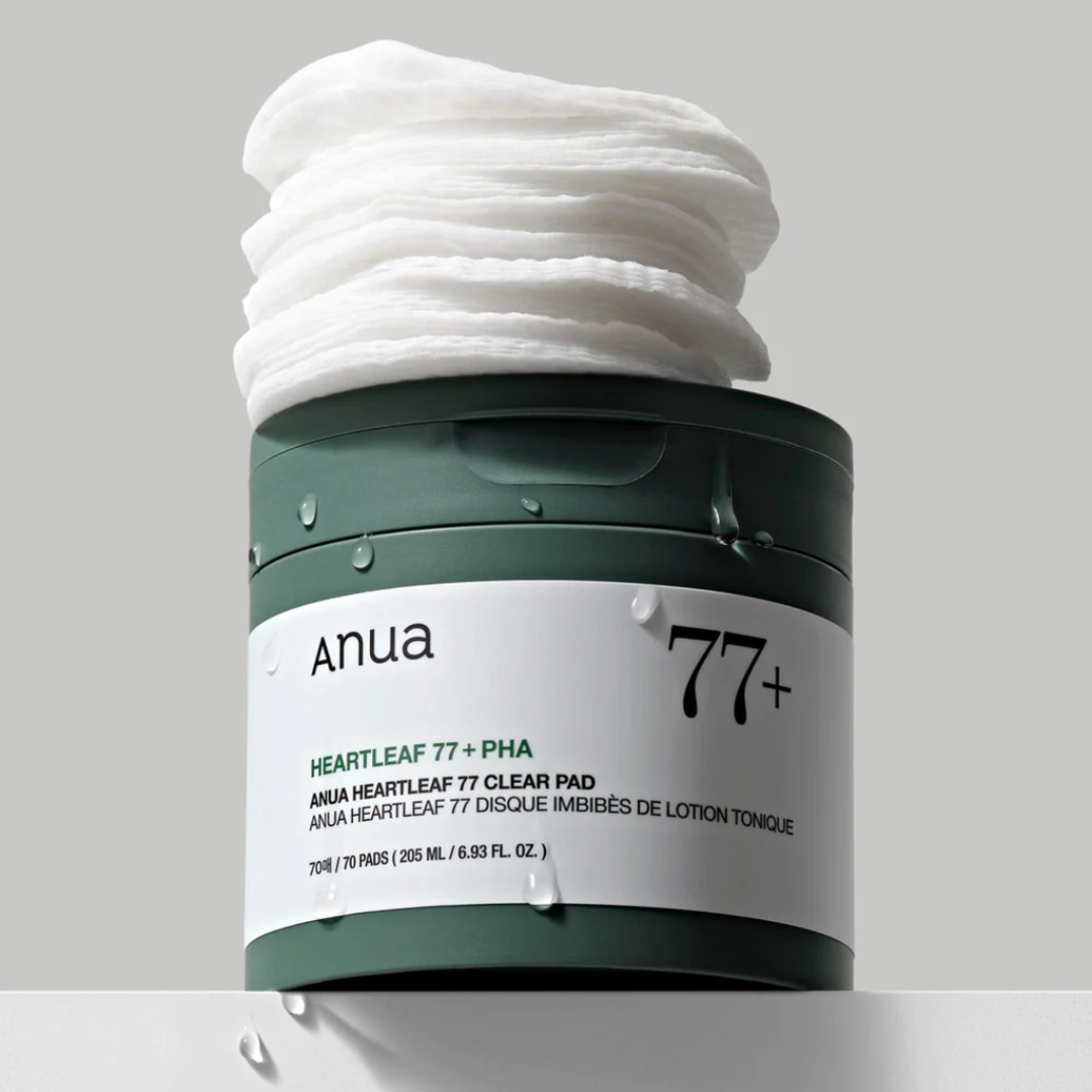 Anua 77+ skincare product with cotton pads on a light gray background