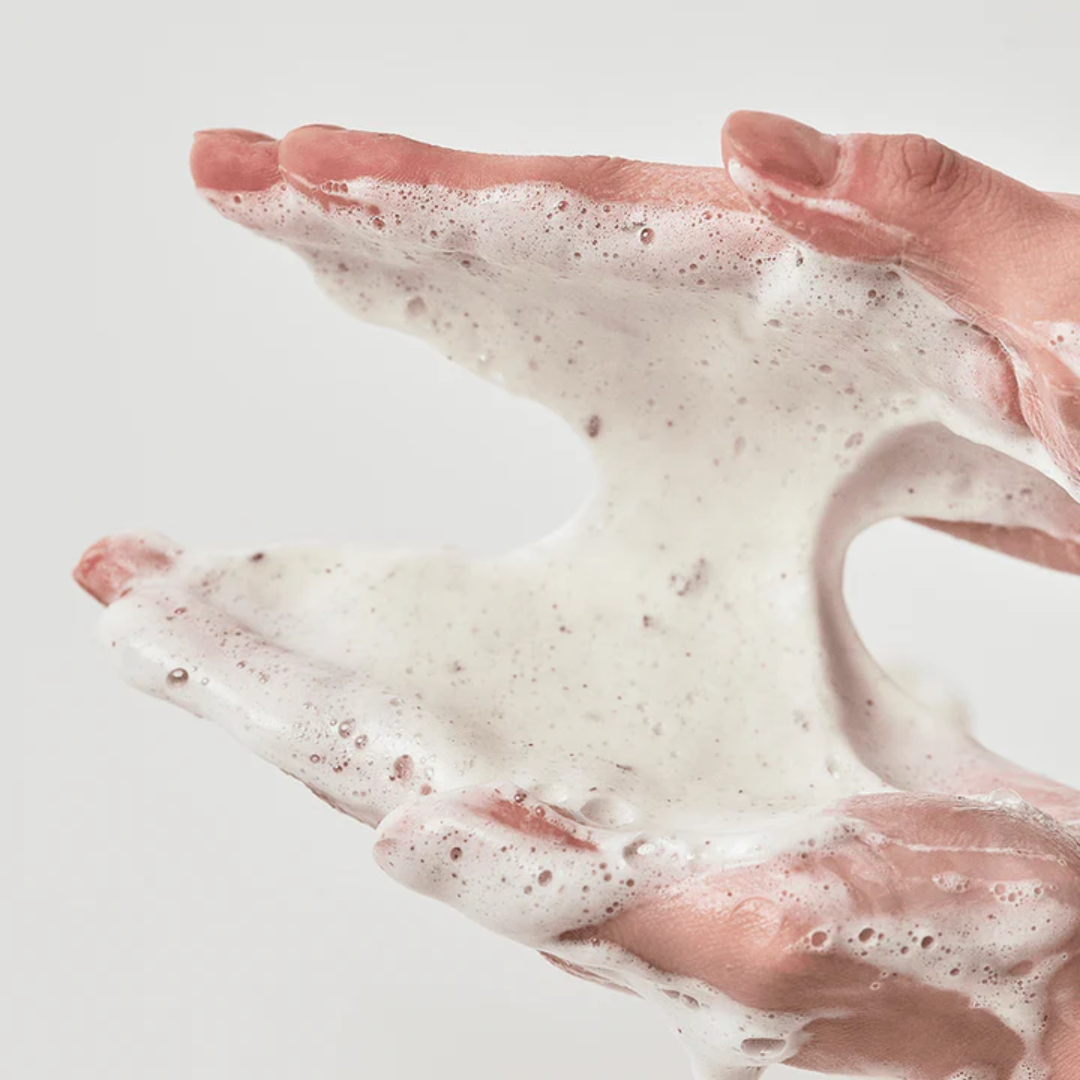 Foamy soap lather on hands against a light background