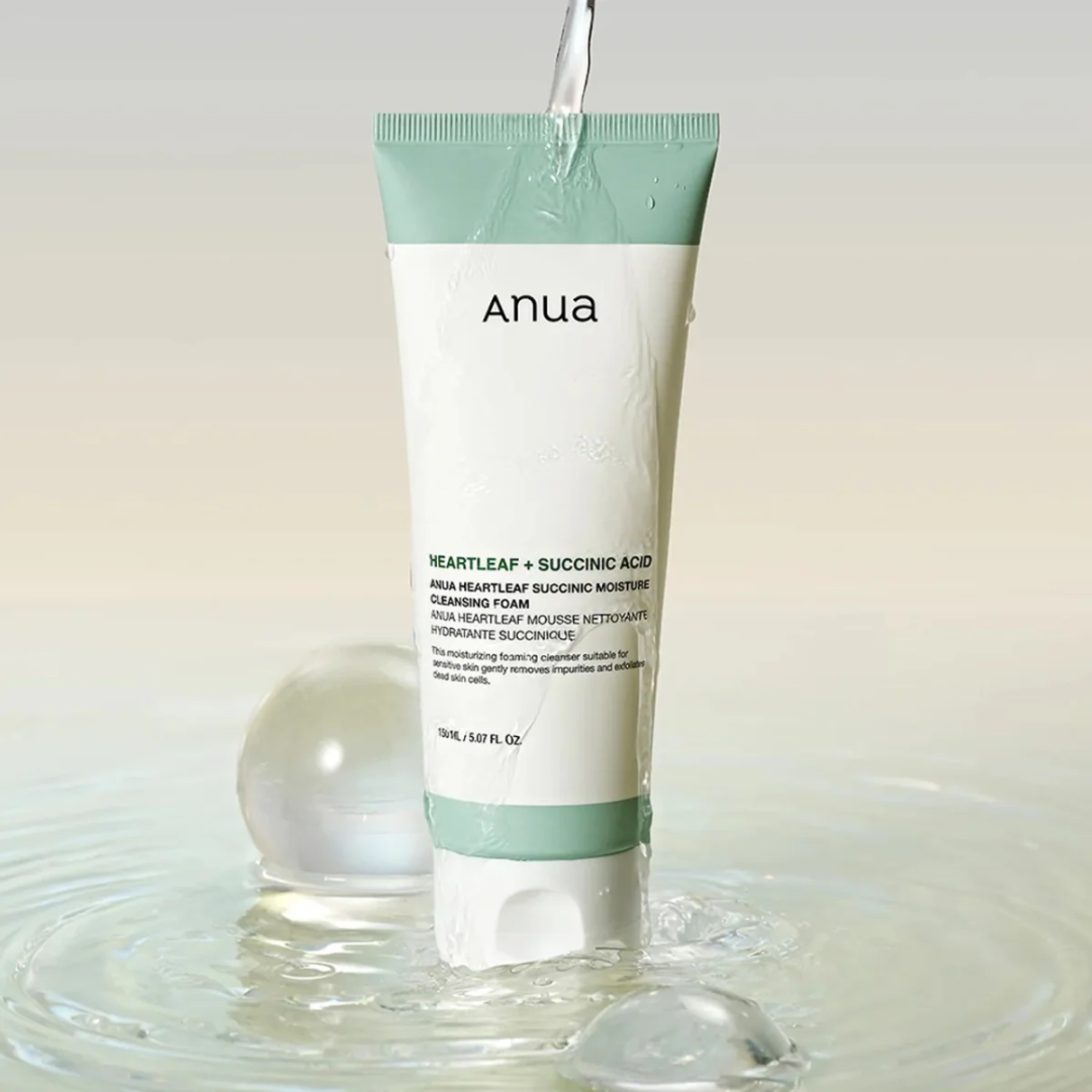 Tube of Anua skincare product with water droplets around it on a light background