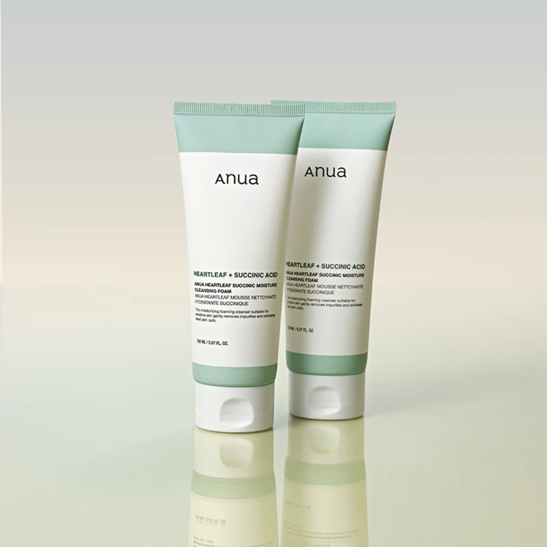 Two Anua skincare products on a reflective surface with a gradient background