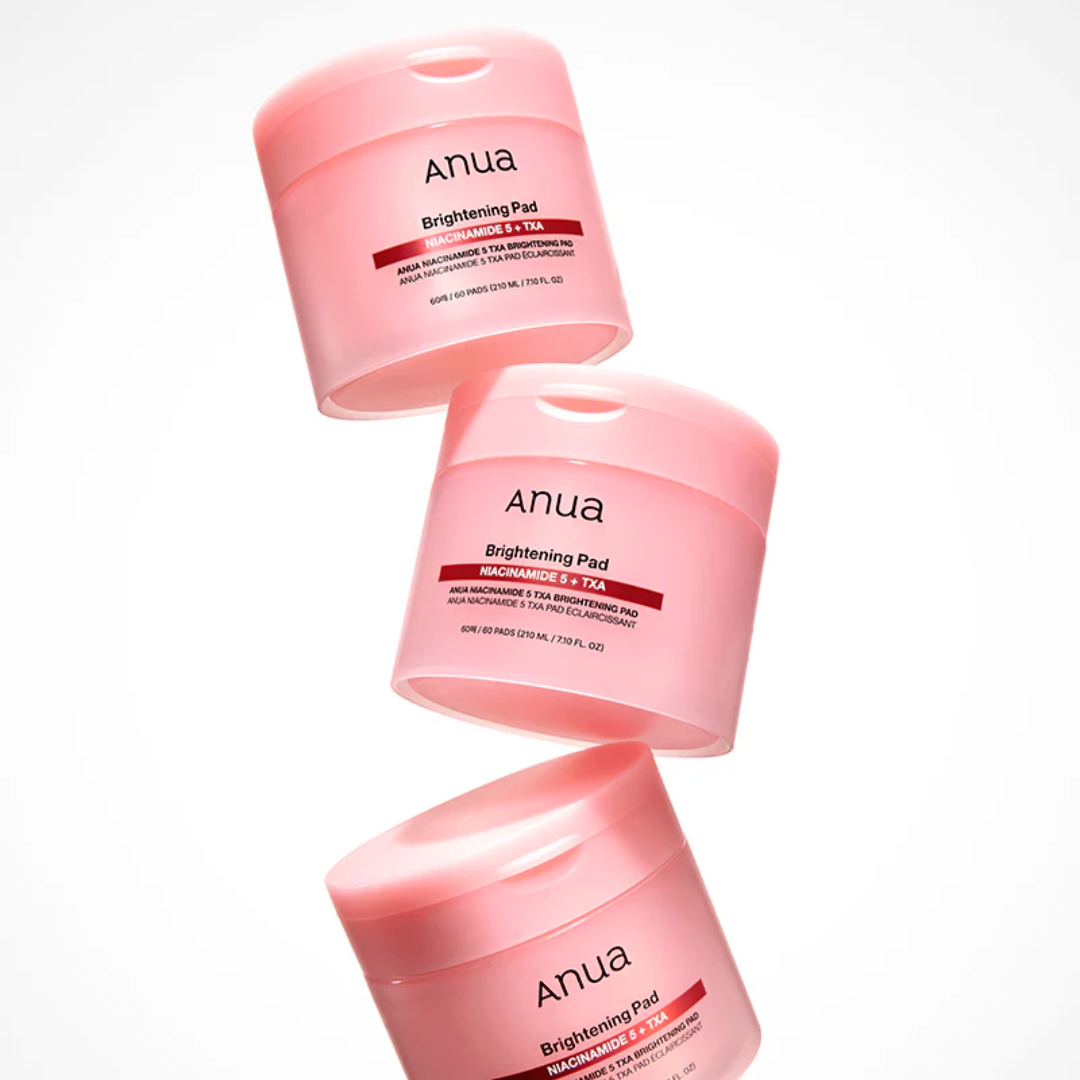 Three pink jars of Anua Brightening Pad on a white background
