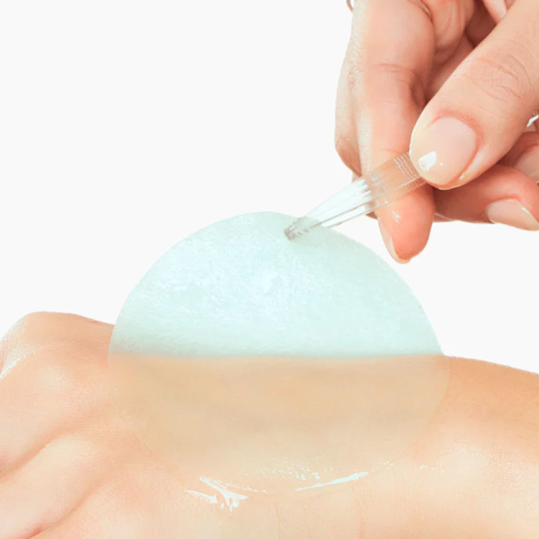 Person applying a pad to a person's skin with a white background