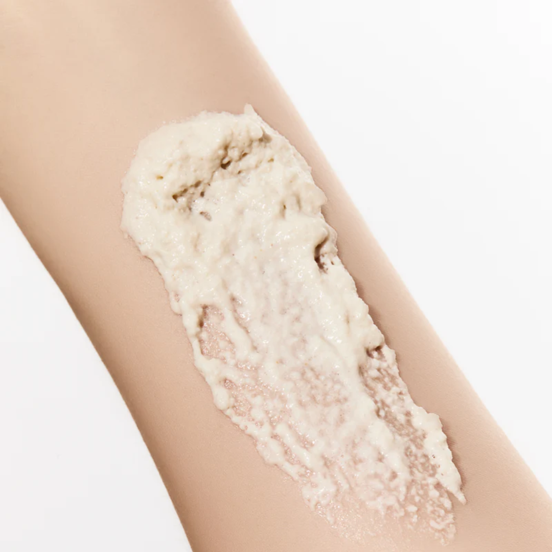 Close-up of a leg with a white cream applied to it on a light background