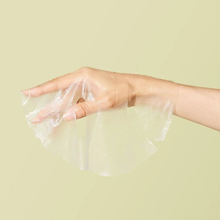 mask hanging over a hand on a yellow background