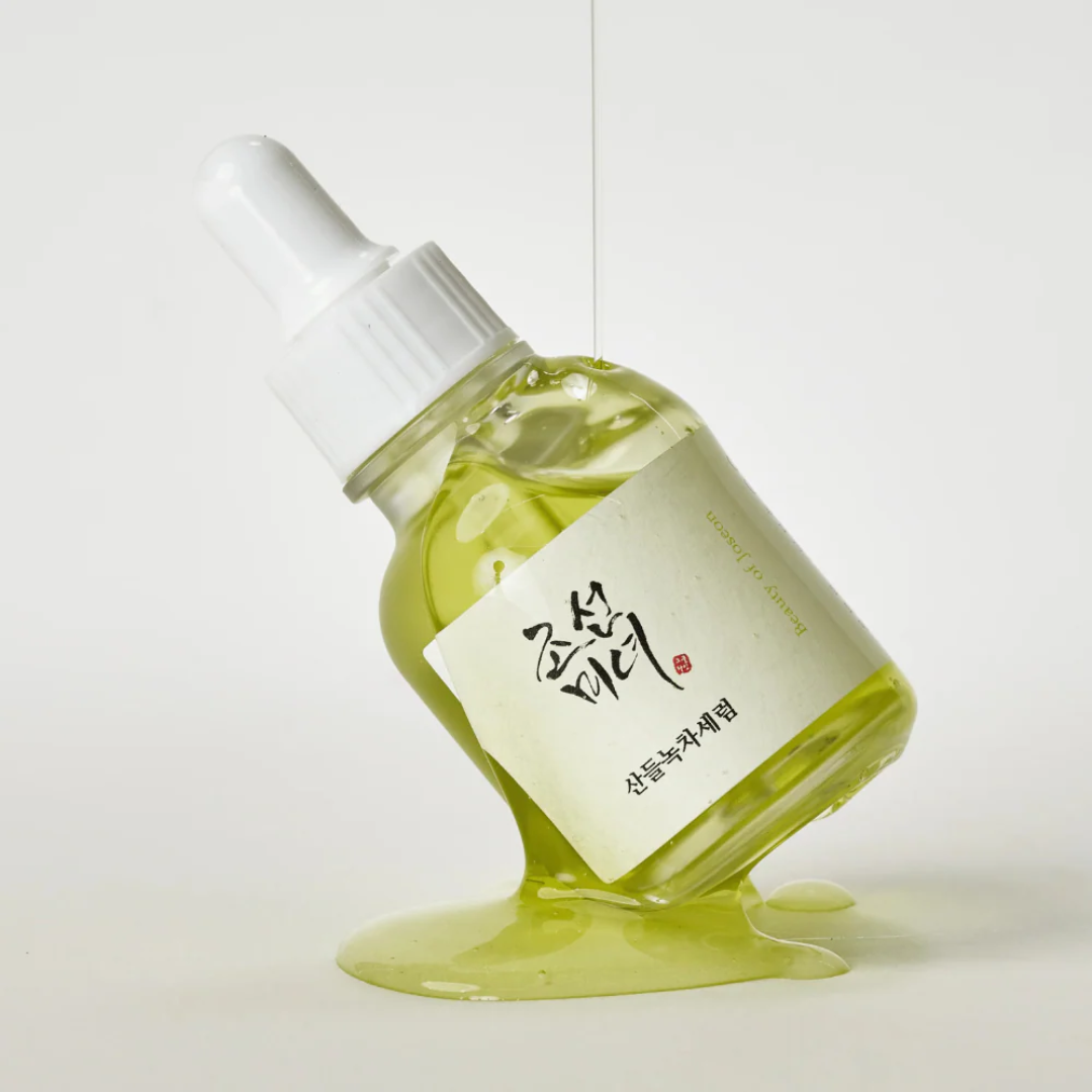 Bottle of green liquid with a white label on a light gray background