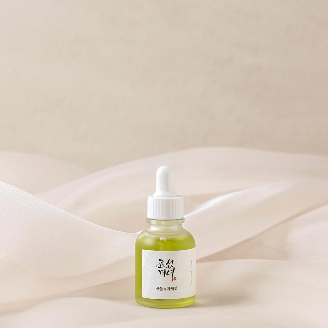 Green bottle with dropper on a soft beige background