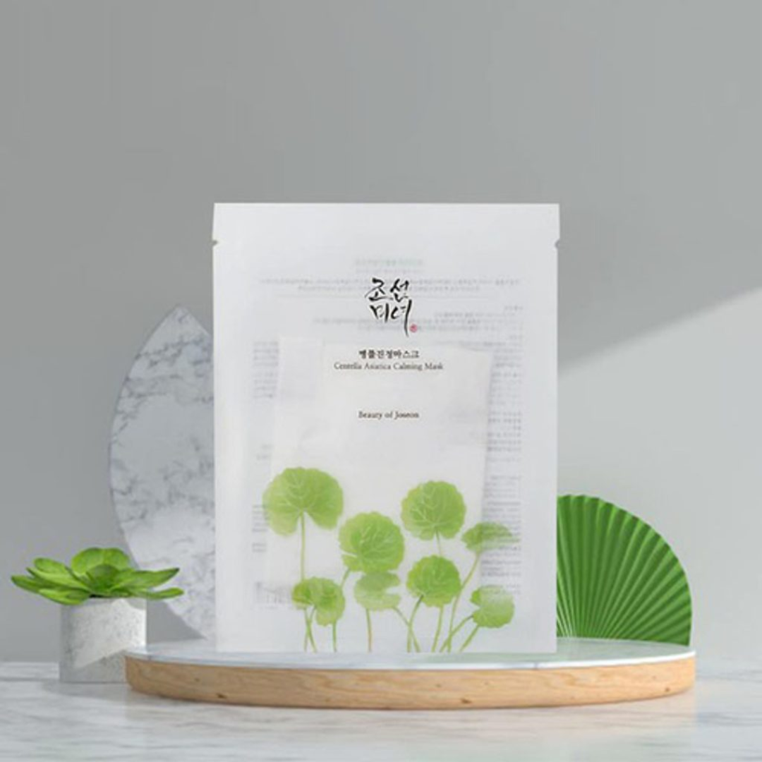 Sheet mask with green leaf design on a gray background