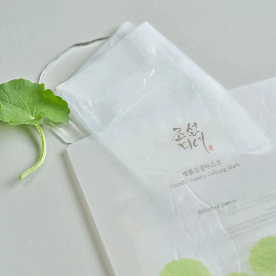 Korean skincare mask with green leaf on a light gray background