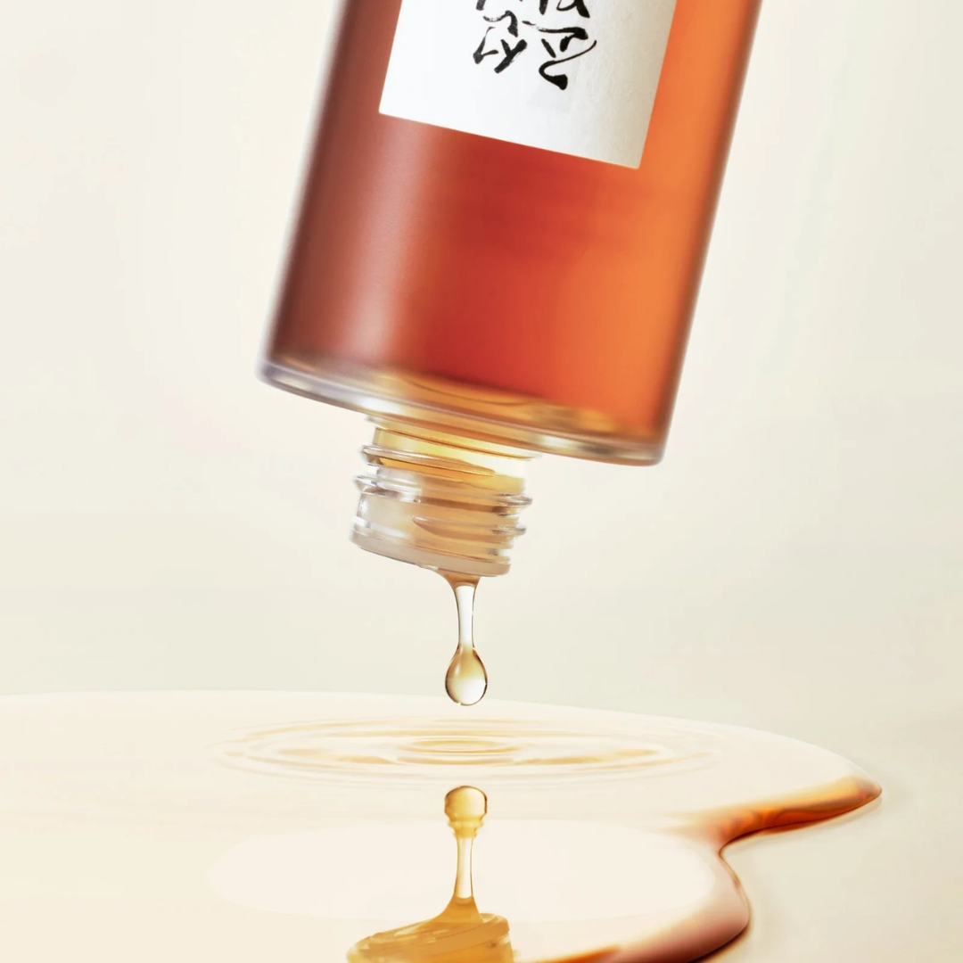 Bottle of toner with a droplet falling onto a light surface