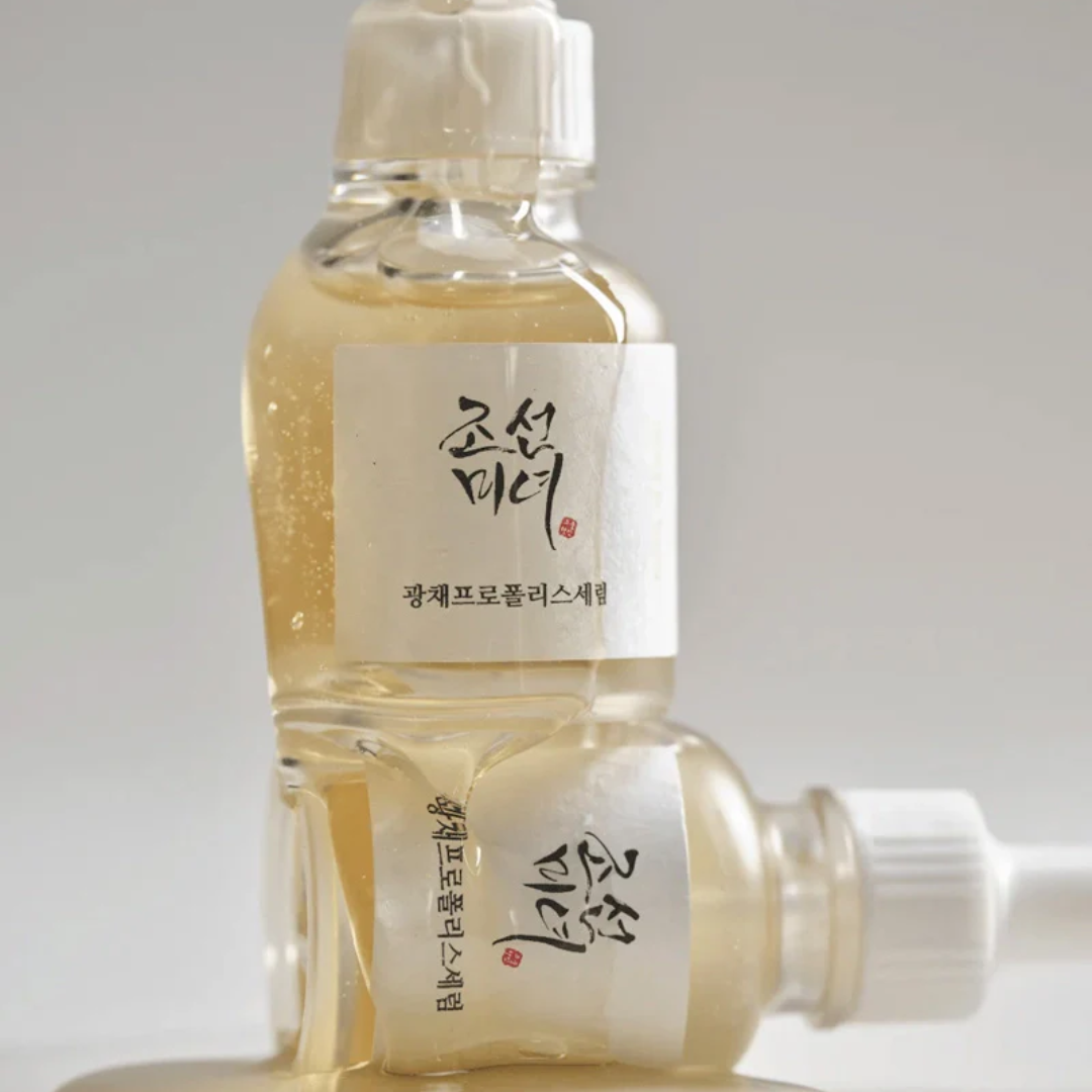 Two clear bottles with white caps and labels on a light gray background