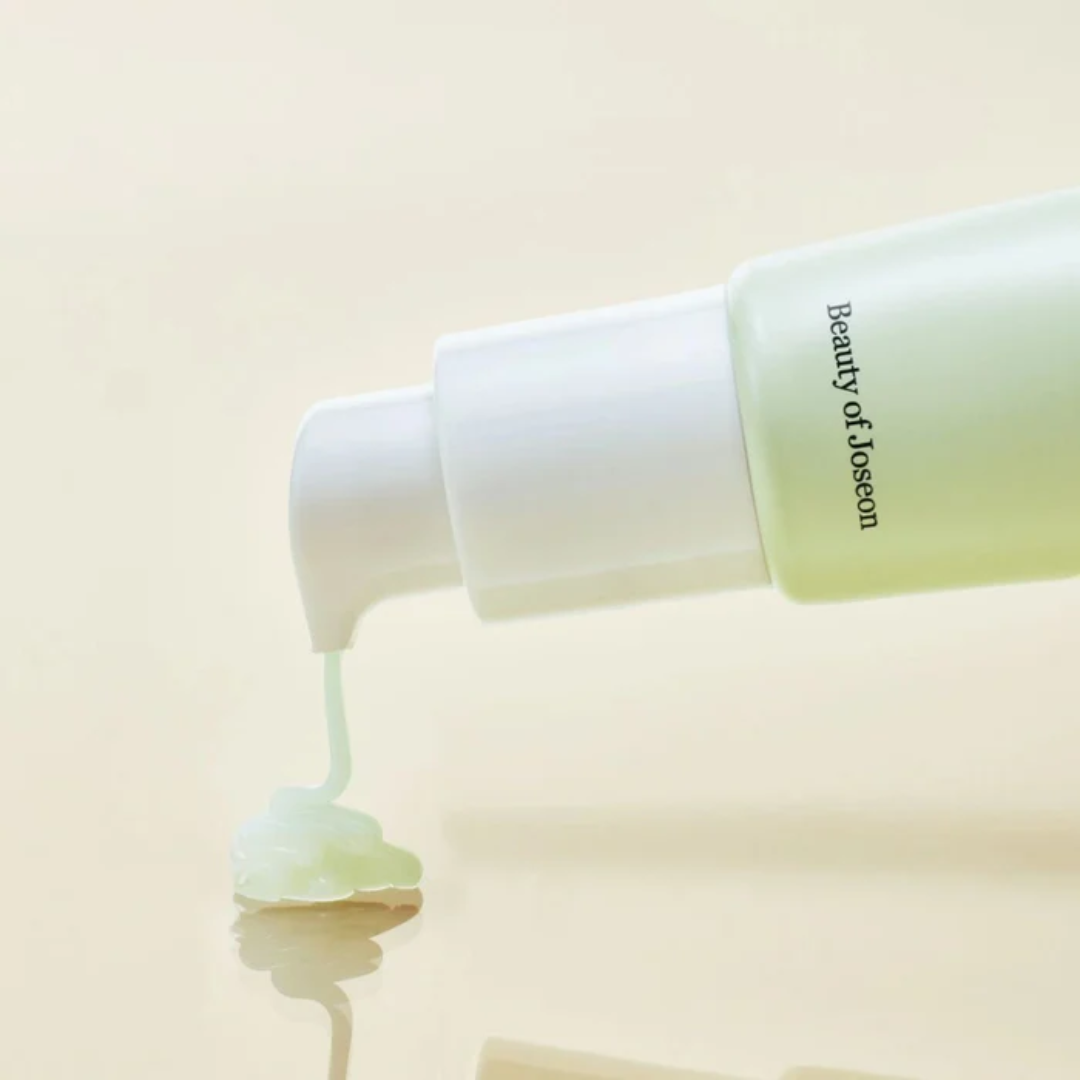 Beauty of Joseon skincare product being applied with a white bottle on a beige background