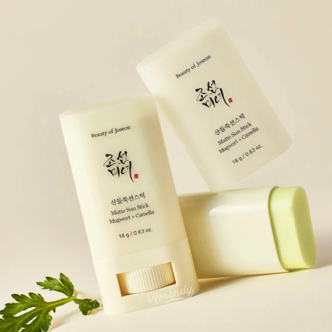 Two matte sun sticks with green leaves on a light beige background