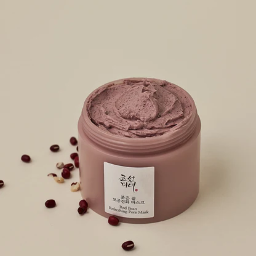 Pink facial mask jar with pomegranate seeds on a beige background