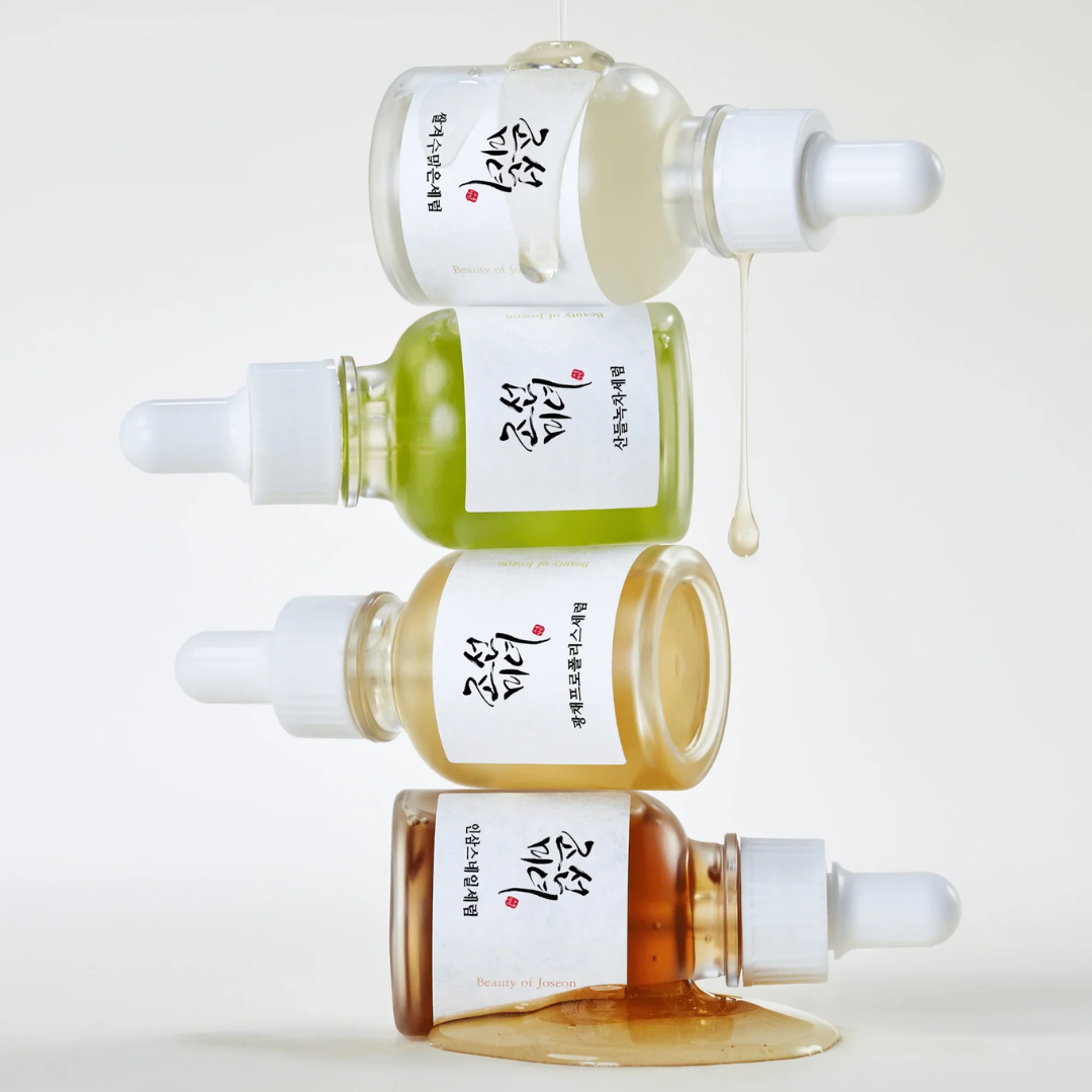 Four dropper bottles with different colored liquids on a white background