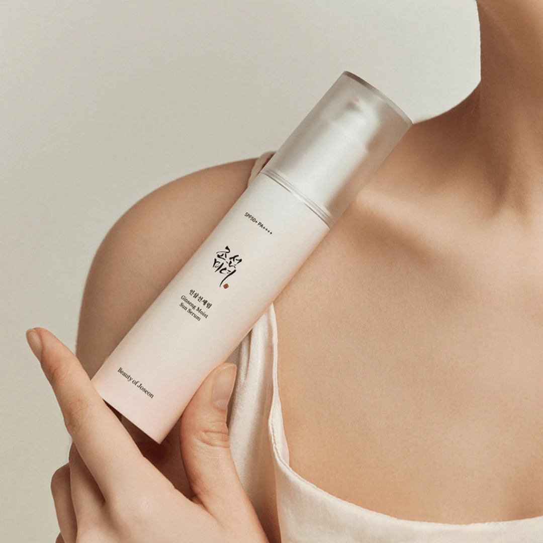 Person holding a skincare product with a neutral background