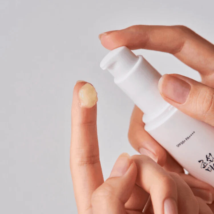 Beauty of Joseon serum squirted onto a finger on a grey background