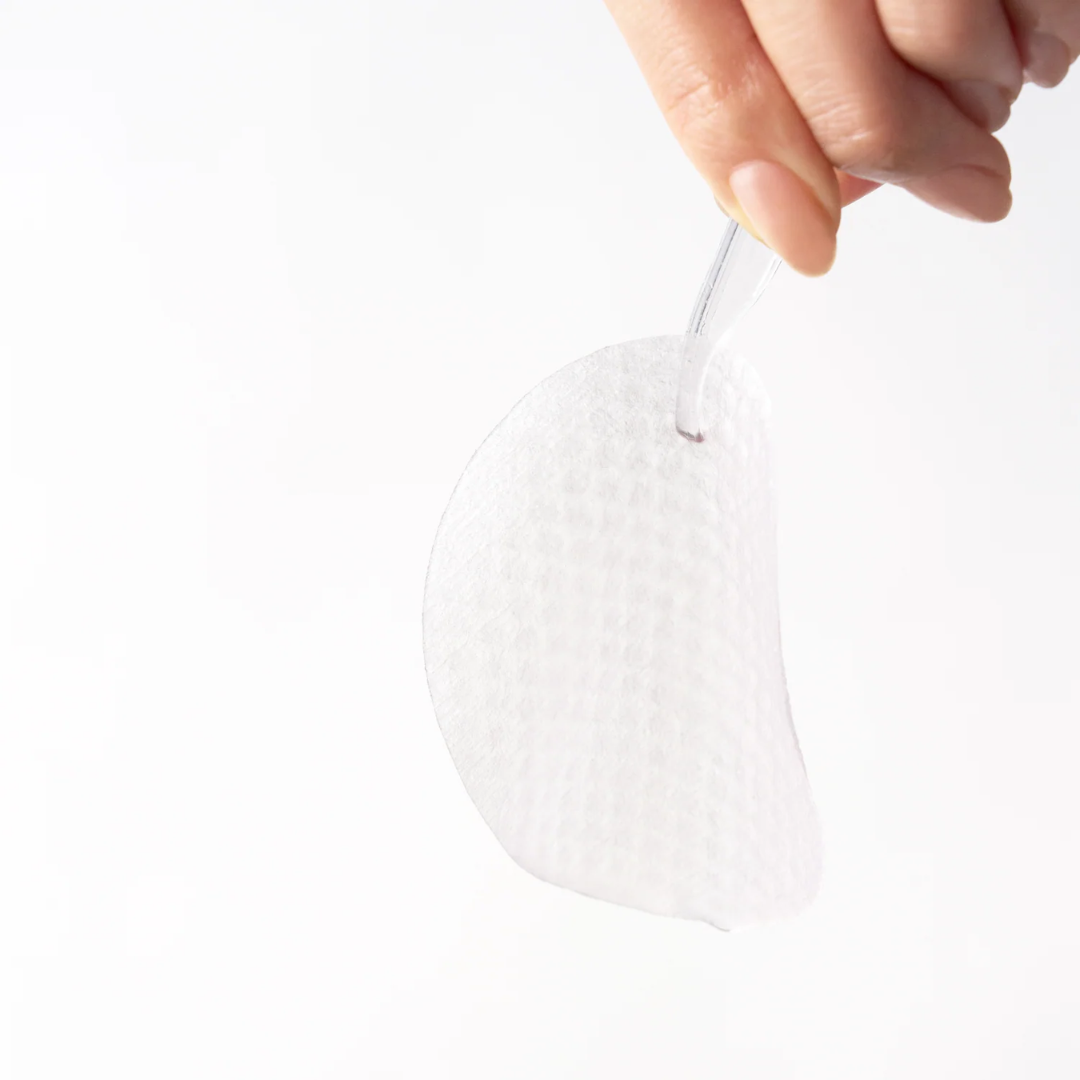 White heart-shaped object held by a hand against a white background