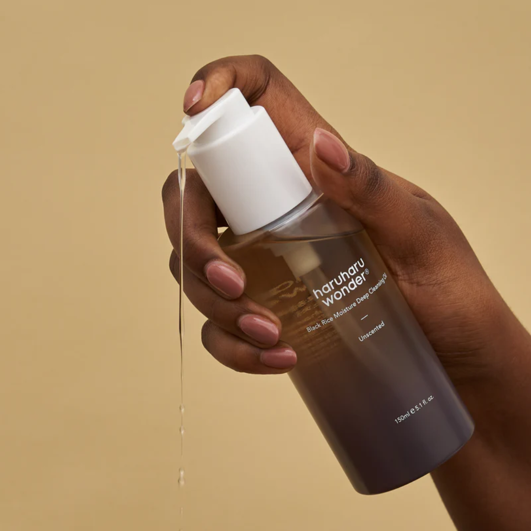 Hand holding a bottle of haruhau wonder product with beige background