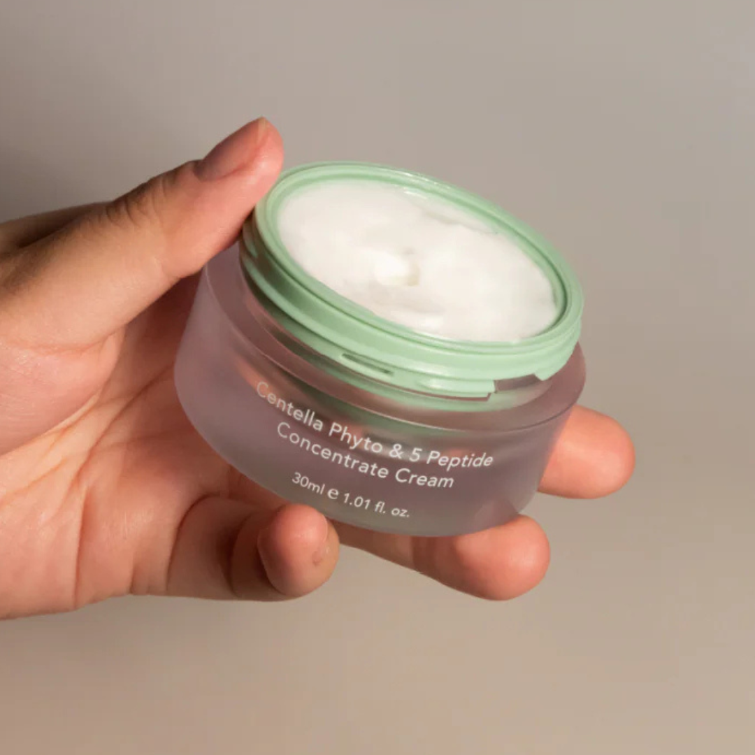 Hand holding a jar of Centella Phyto & 5 Peptide Concentrate Cream against a neutral background