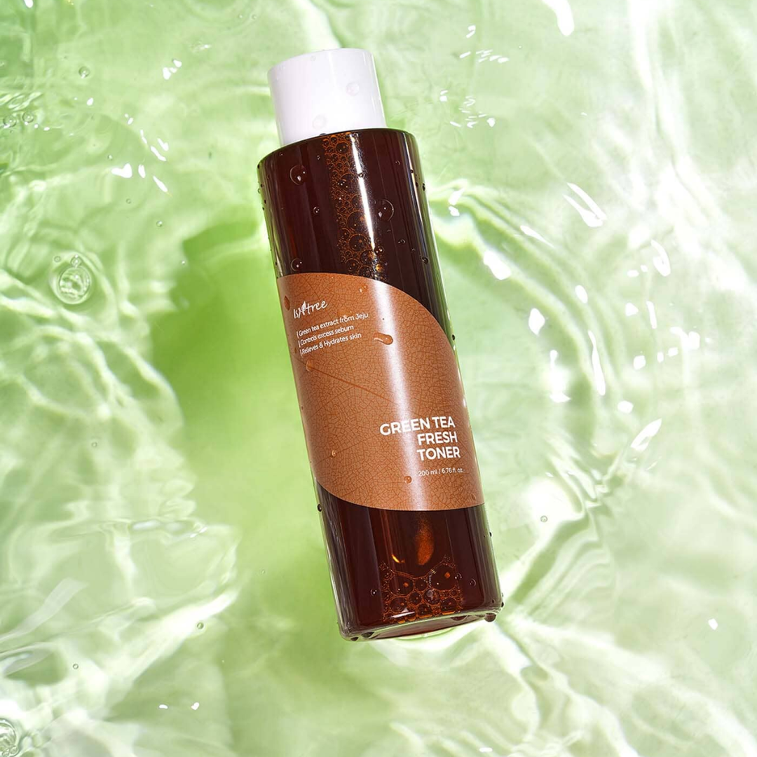 Brown bottle of green tea toner on a green textured background