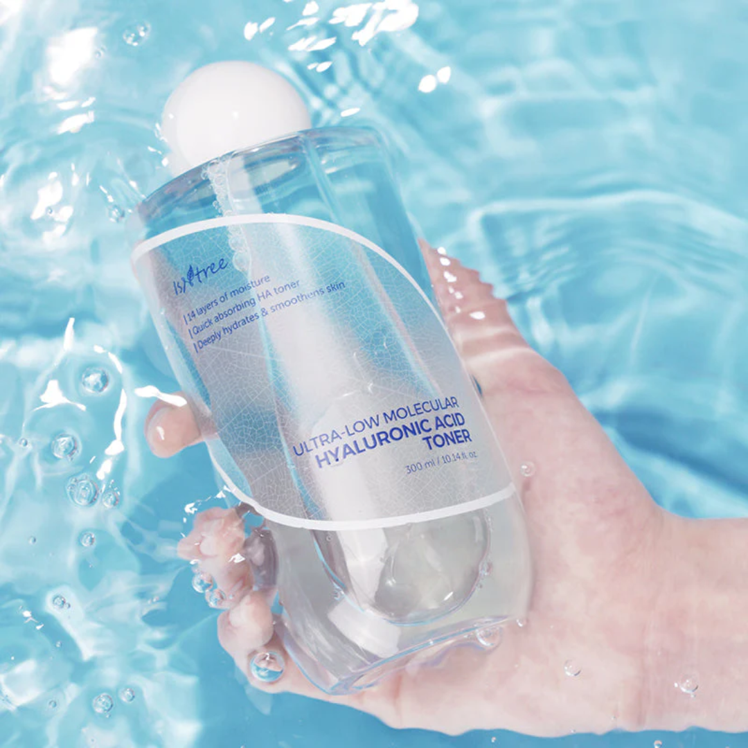 Hand holding a bottle of toner with water background
