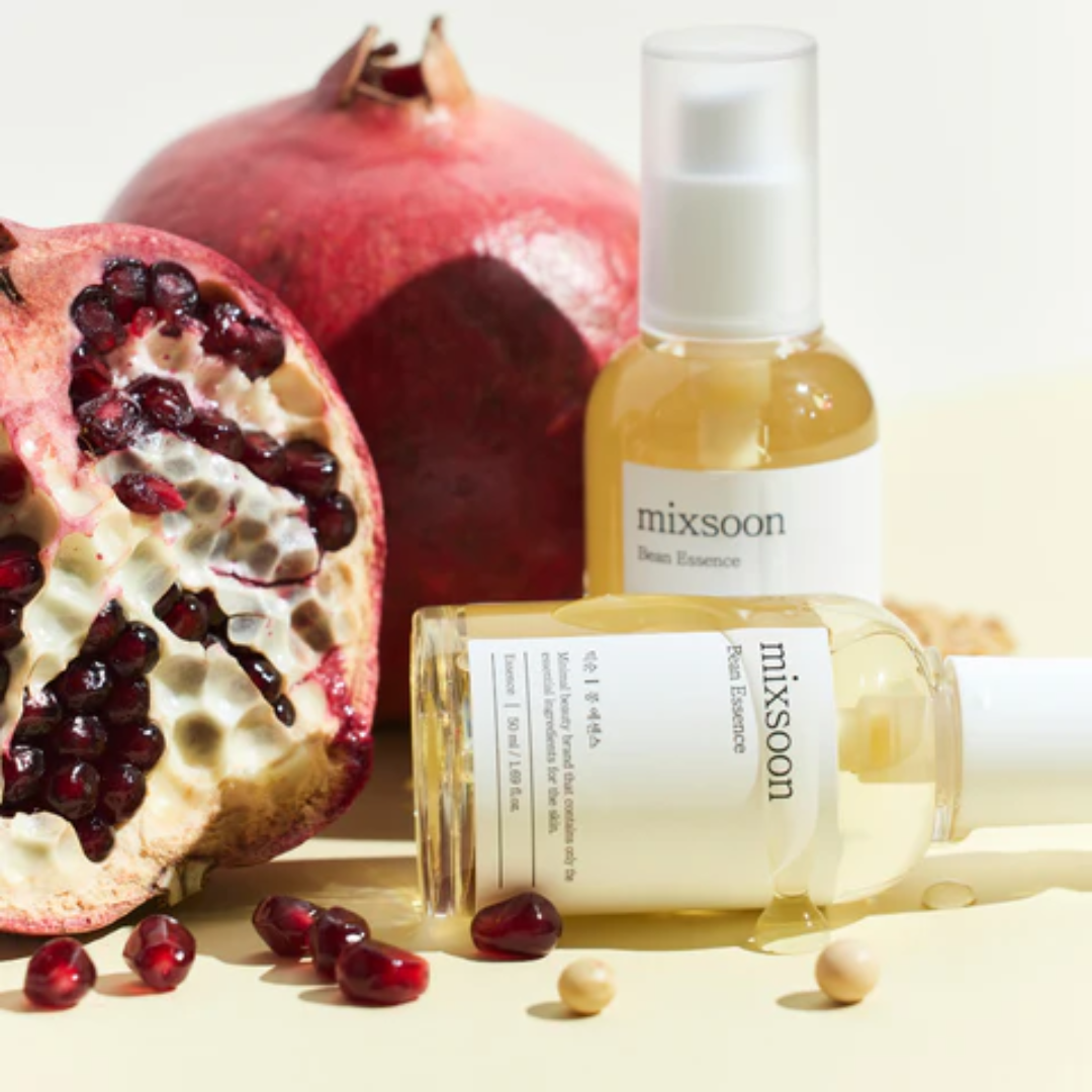 Two bottles of 'mixsoon' skincare products with pomegranates on a light background