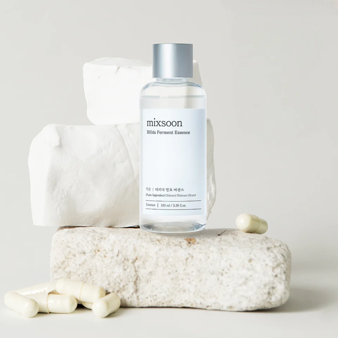 Bottle of mixsoon skin ferment essence on a textured stone surface with a white towel.