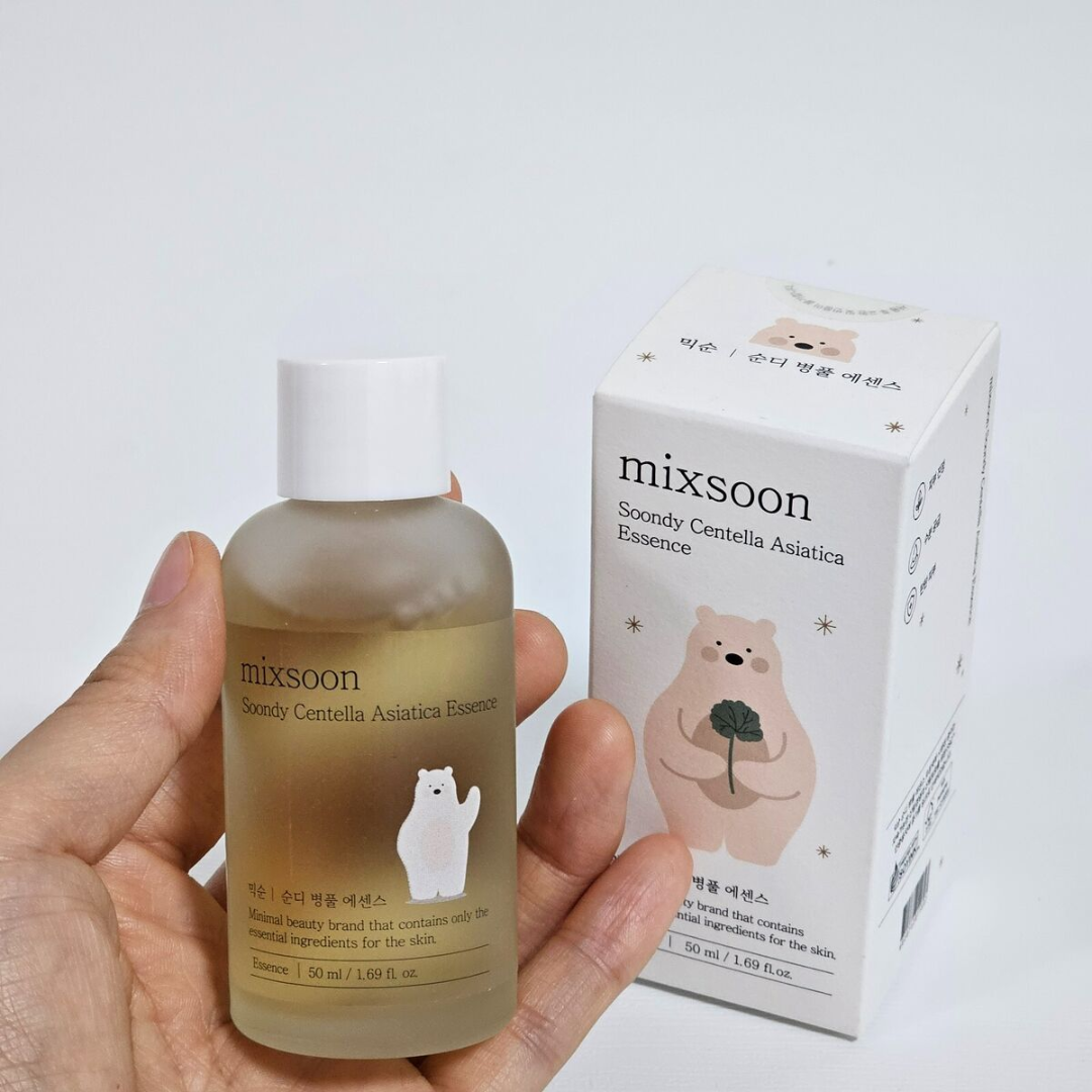 Hand holding a bottle of 'mixsoon' Centella Asiatica Essence with its packaging on a light gray background.