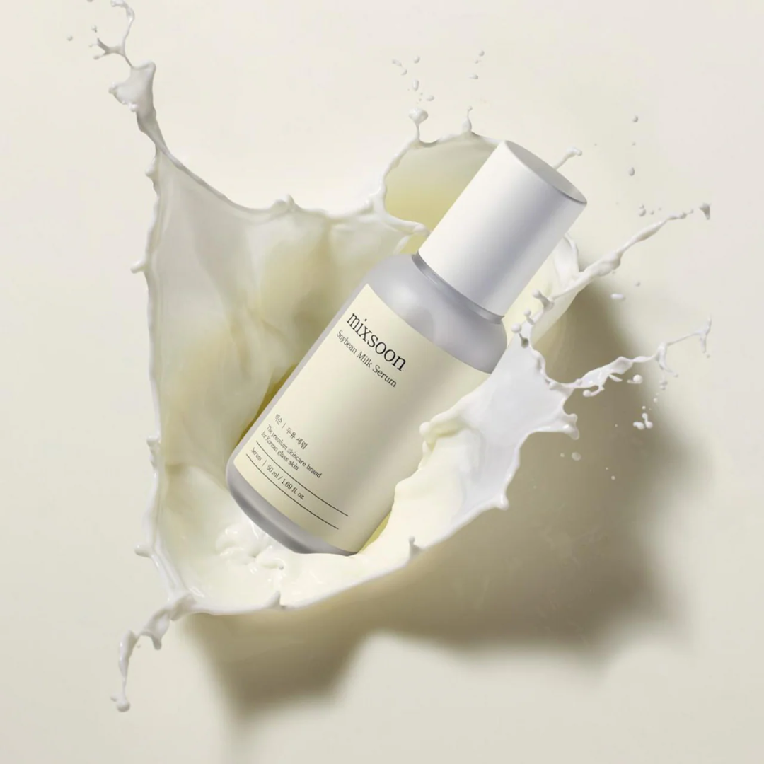 Skincare serum bottle with 'mixsoon' branding surrounded by a splash of cream on a light background