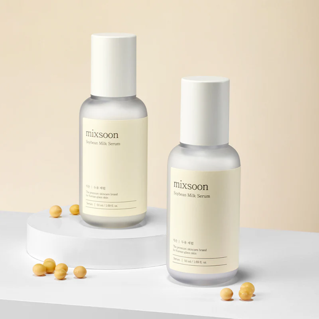 Two bottles of mixsoon Whitening Milk Serum on a light beige background with small yellow objects around.