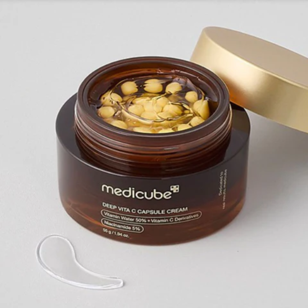 Medicube Deep Vita C Capsule Cream jar with a white applicator on a light gray background