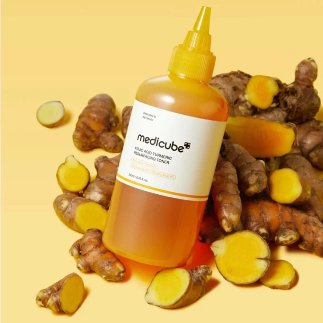 Bottle of Medicube product with turmeric roots on a yellow background