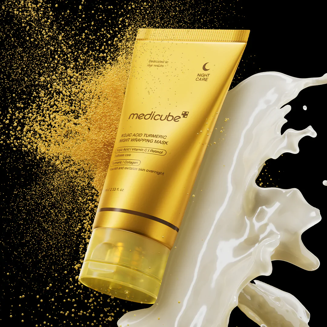 Gold tube of Medicube skincare product with gold powder and white cream on a black background