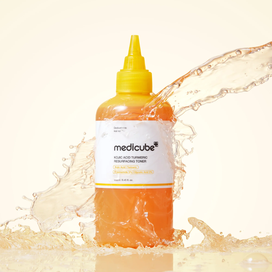 Medicube toner bottle with splash effect on a beige background