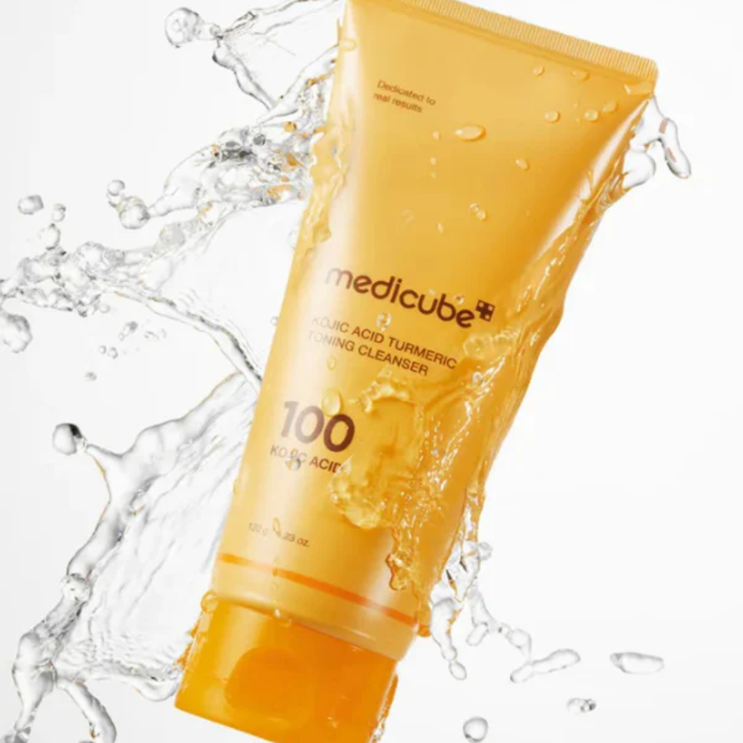 Orange tube of Medicube cleanser with water splashes on a white background