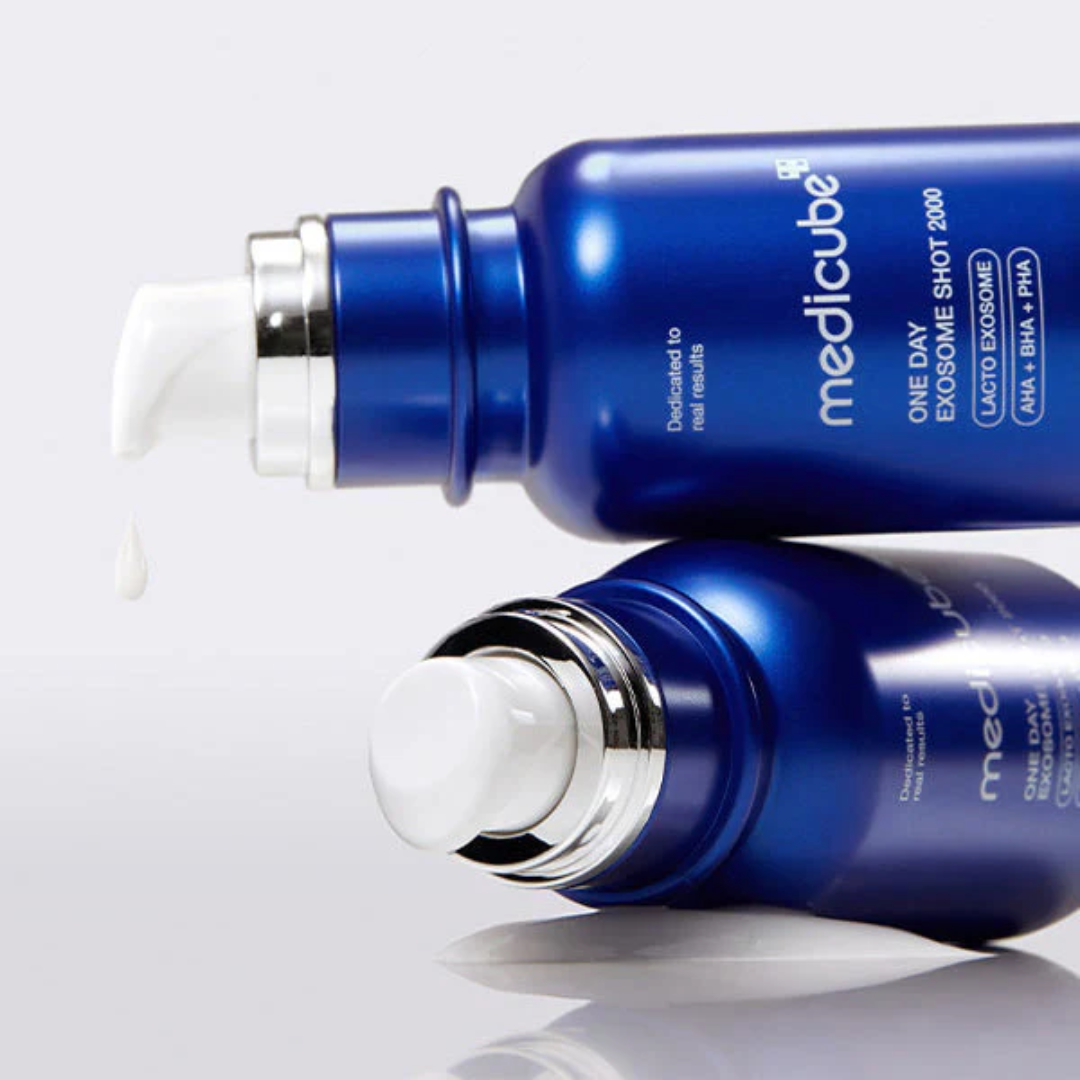 Two blue skincare bottles with silver caps on a white background