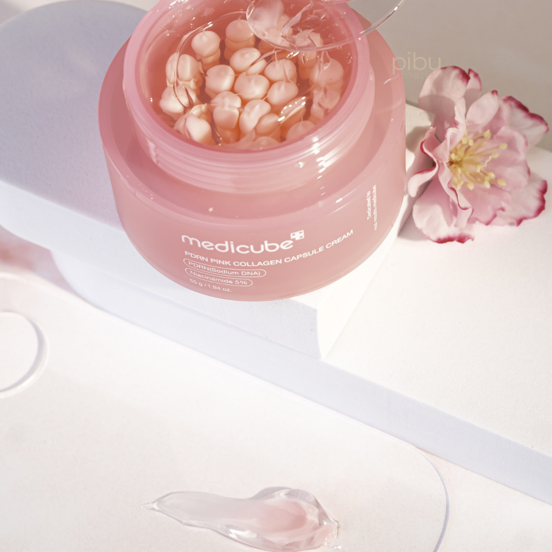 Pink jar of Medicube product with a flower on a white background