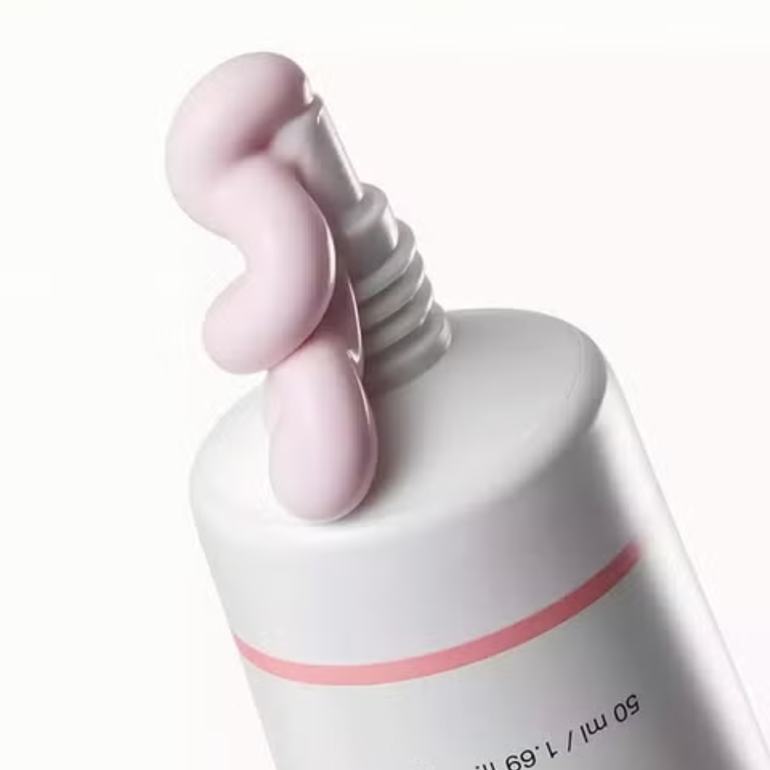 White and pink skincare product with pump on a white background