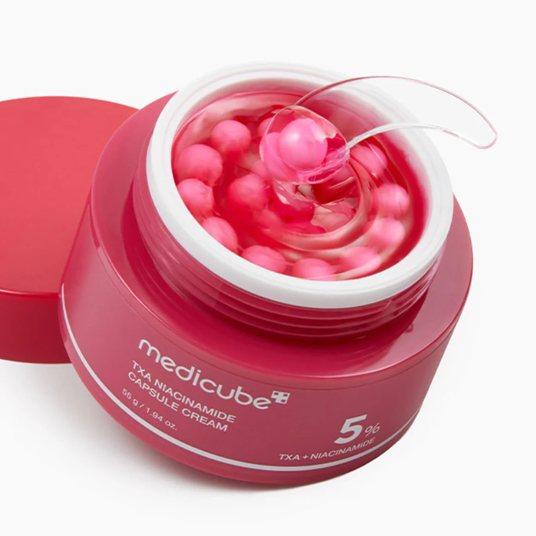Pink jar of Medicube cream with pink capsules on a white background