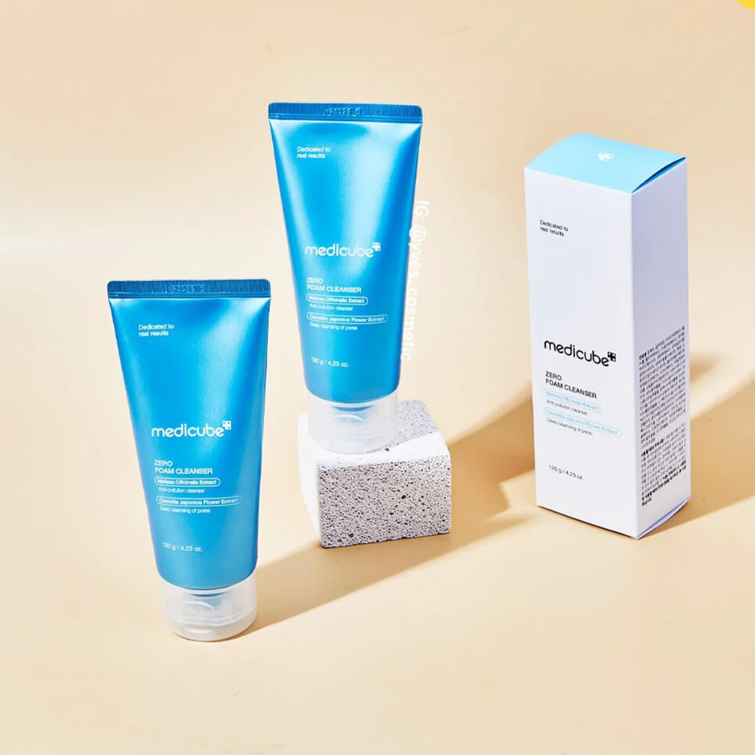 Two blue tubes and a white box of Medicube cleanser on a beige background